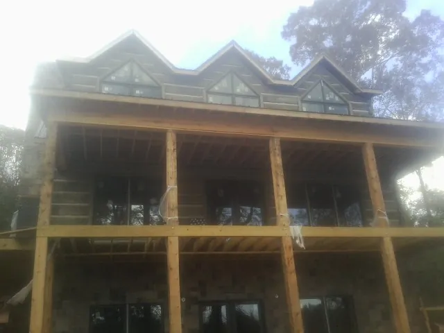 Dormers and porch framing on a large log home under construction — Roof Coating work by our crew in Nunica
